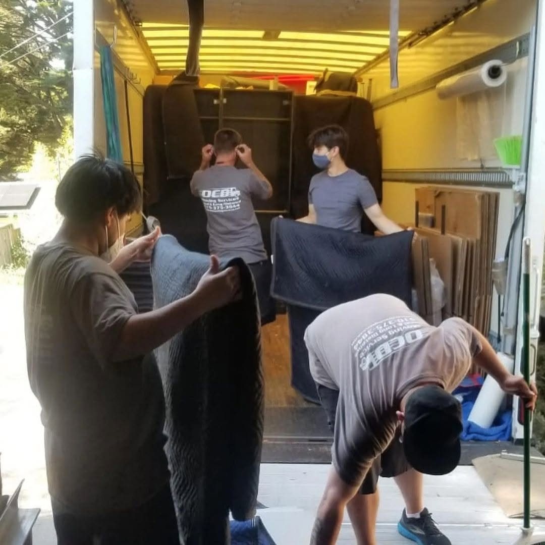 OCD Moving Services crew loading and pad-wrapping furniture in the truck