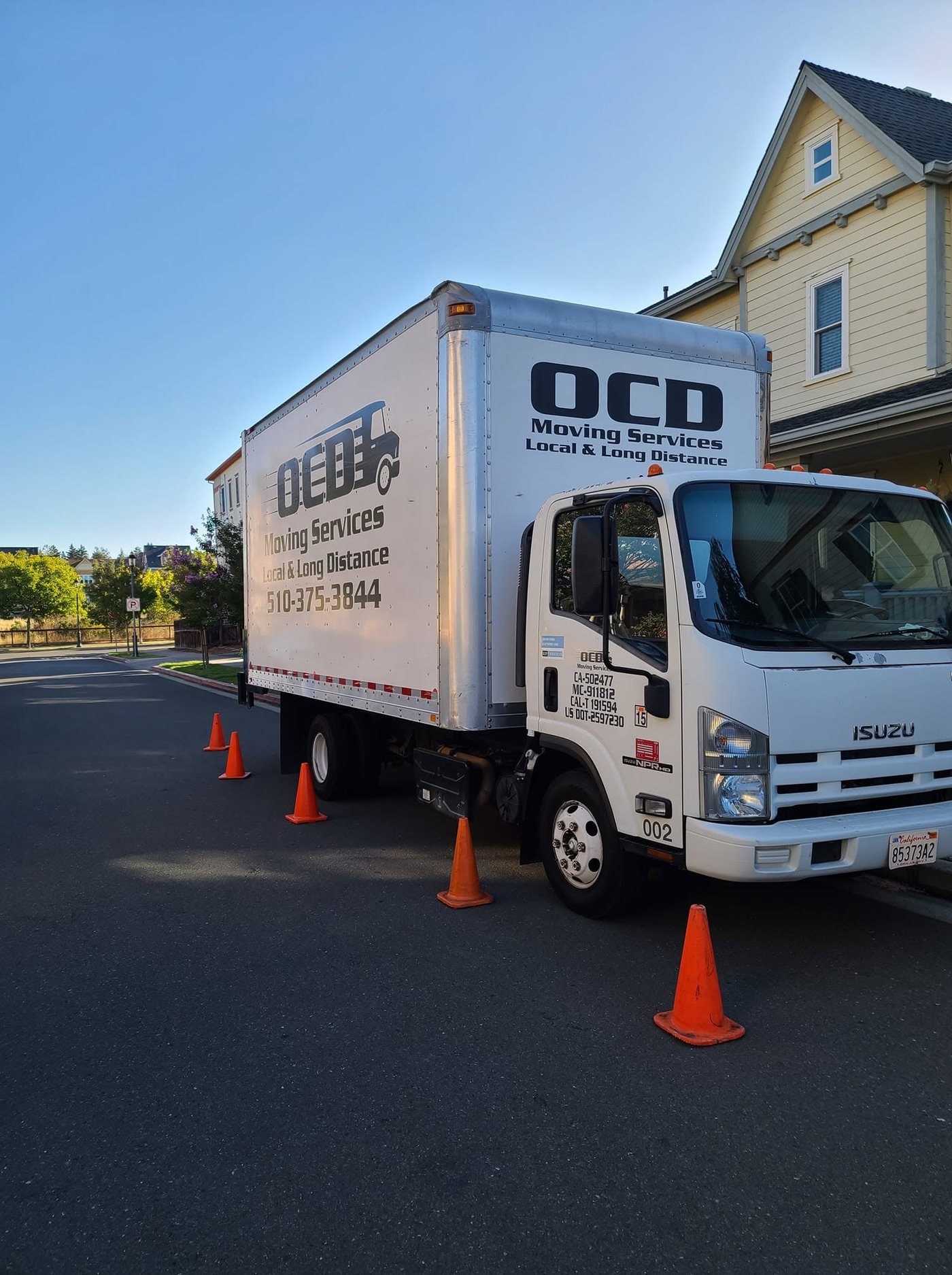 A clean OCD Moving Services box truck parked at a customer's home, ready to load