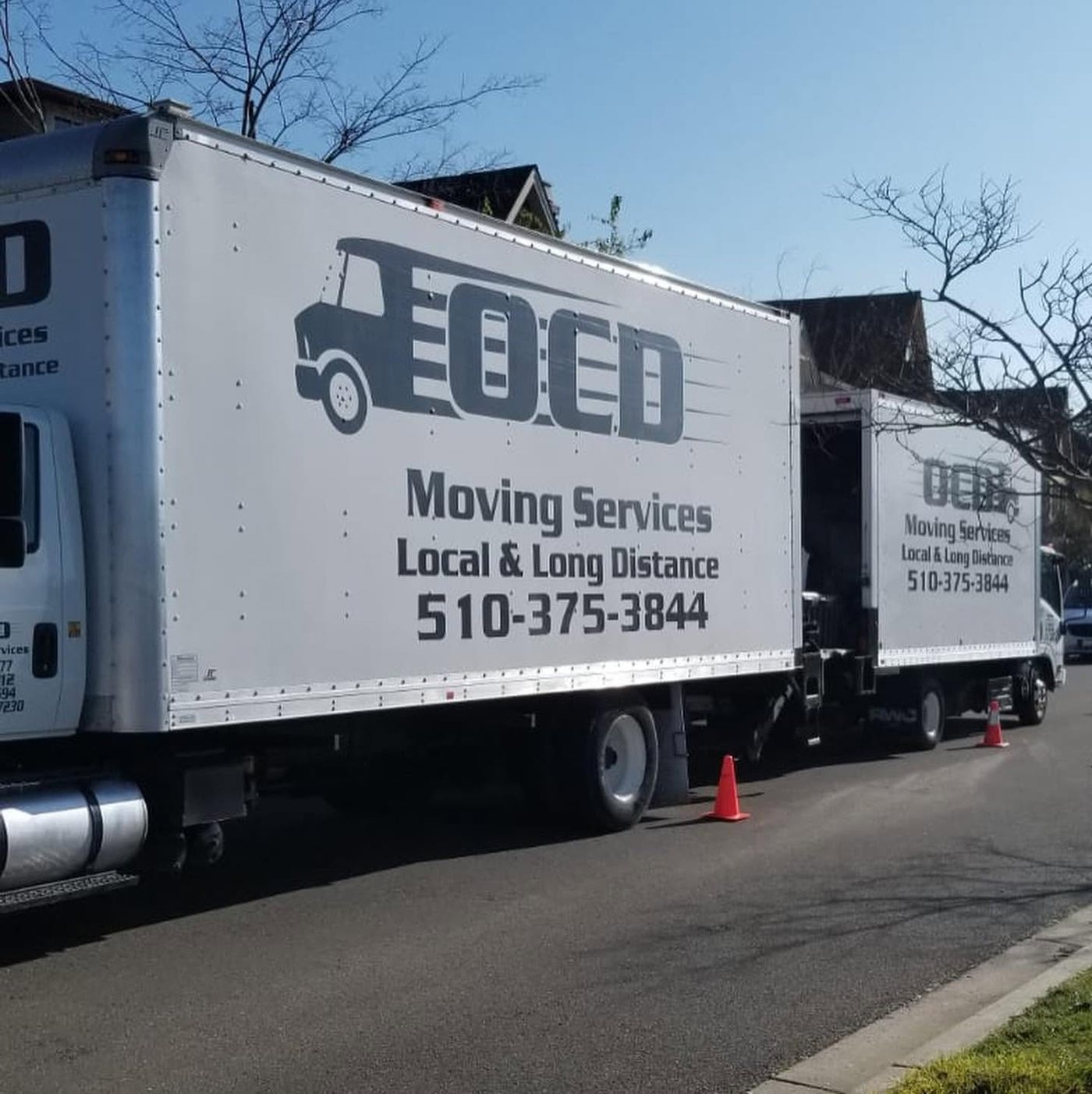 OCD Moving Services trucks parked on a residential street during a move